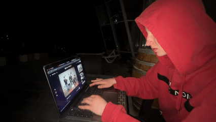 Person uses laptop outdoors at night in Sochi