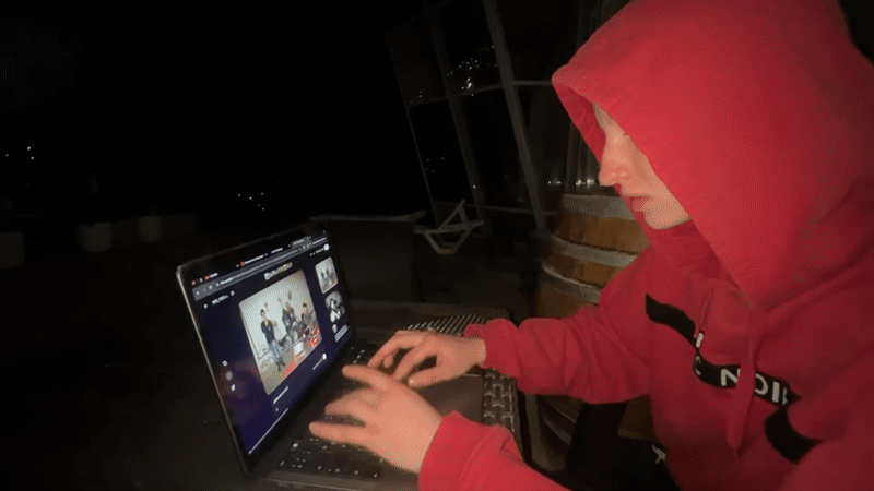 Person uses laptop outdoors at night in Sochi