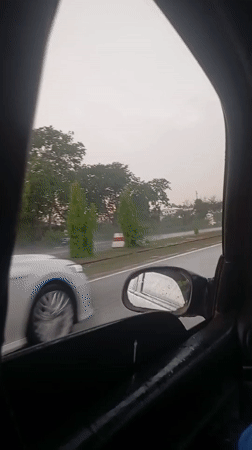 Rainy afternoon traffic documented from moving vehicle in Abuja