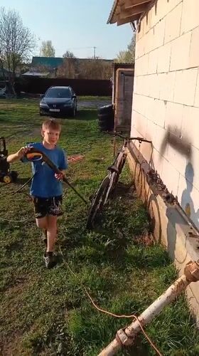 Boy washes bike, German Shepherds play in Andreyevo yard