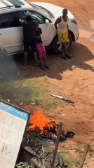Trash fire burns beside a spiked wall in Onitsha