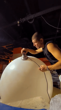 Sanding a large white sphere in Karaganda, Kazakhstan