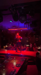 Singer performs in sequined jacket at London restaurant