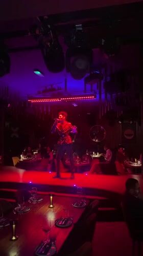 Singer performs in sequined jacket at London restaurant
