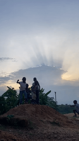 Children play on dirt mound in Unwana, Nigeria