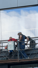 Construction workers perform scaffold work near building window
