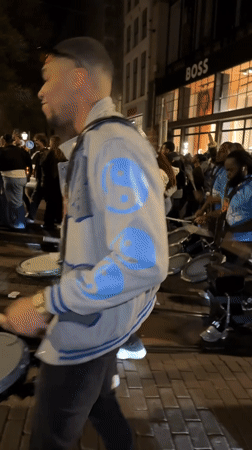 Amsterdam street celebration features drums, dancing, fireworks