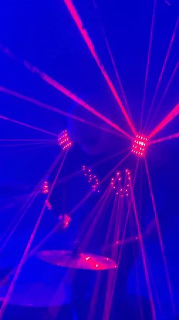 Light-up drummer performs for dancing crowd at laser-lit Moldova event