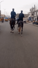 Horseback riders traverse paved road in Fagge A, Nigeria