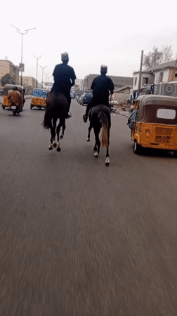Horseback riders traverse paved road in Fagge A, Nigeria