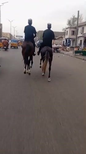 Horseback riders traverse paved road in Fagge A, Nigeria