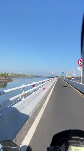 Motorcycle crosses bridge with guardrails in Kuta, Indonesia