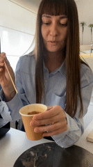 Woman adds cinnamon to coffee in Votkinsk cafe