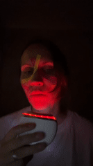Person applies glowing kinesiology tape in geometric face patterns