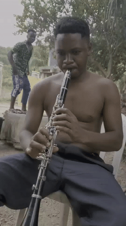 Street musician plays clarinet outdoors in Mararaba, Nigeria