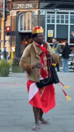 Crowned figure dances barefoot on London streets
