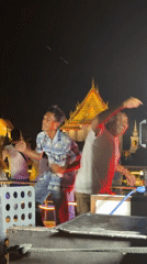 Nighttime boat performance staged near illuminated Wat Arun temple