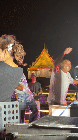 Nighttime boat performance staged near illuminated Wat Arun temple