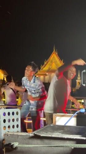 Nighttime boat performance staged near illuminated Wat Arun temple