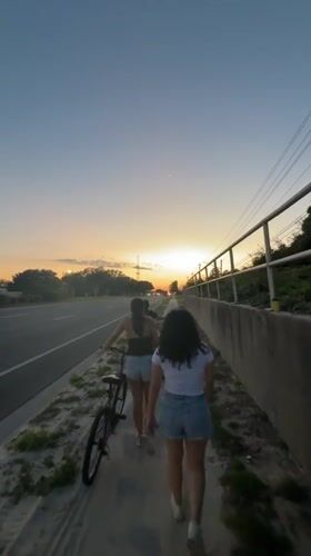 Two women walk with bicycle at Panama City Beach