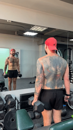 Dumbbell curls in a Voronezh gym, mirror reflection in frame.