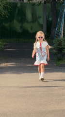 Young girl in heart sunglasses walks Moscow path