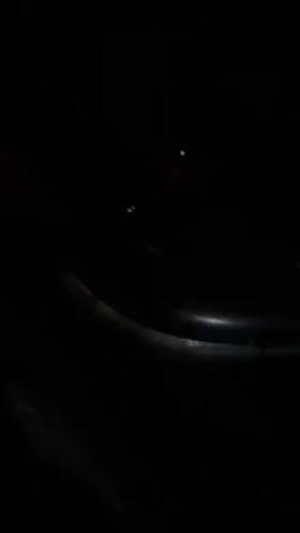 A close-up shot in the dark shows the orange blinker of a car flashing on and off.