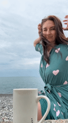 Woman in heart-patterned robe enjoys morning beach moment in Sochi