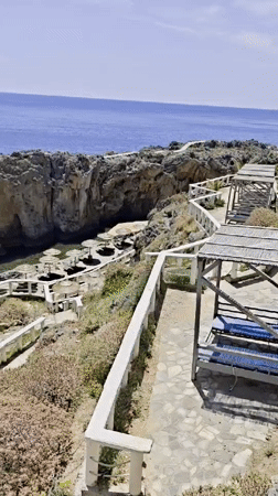 Tourist documents scenic coastal views in Plakias, Greece