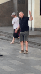 Street band plays as people dance on a nearby paved area