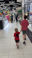 Children walk hand-in-hand through Tashkent shopping mall