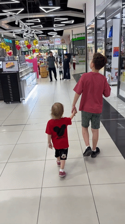 Children walk hand-in-hand through Tashkent shopping mall