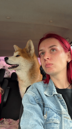Pink-haired woman travels with dog, child in rainy Kamyennoye