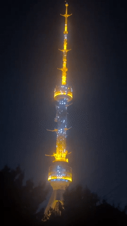 Tashkent tower glowing at night, yellow and white lights