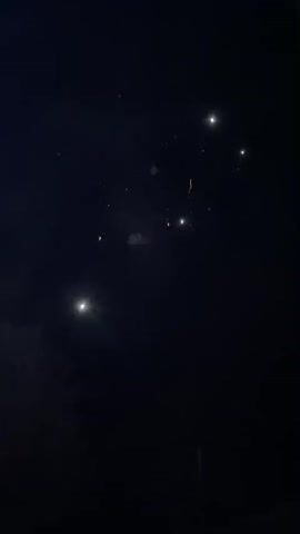 The video shows fireworks at night. The first firework is red and gold. The second is various colors, including white, red, and green.