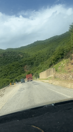 Vehicle travels cracked mountain road near Brikcha, Morocco