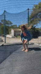 Girl plays on backyard trampoline in Montenegro village