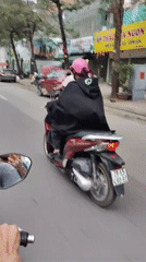 Motorcycle rider documents typical morning street life in Hanoi