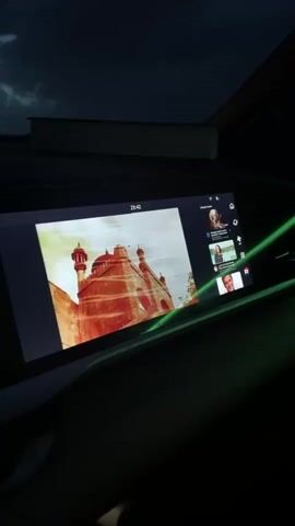 A point-of-view video from inside a car driving on a highway at night shows the dashboard and the road ahead. The car's headlights illuminate the road. The dashboard displays the time, speed, and other car information. The sky is dark with clouds.