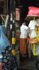 Late-night street food and traffic on a Randuagung roadside
