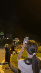 Nighttime fireworks draw a crowd with phones out