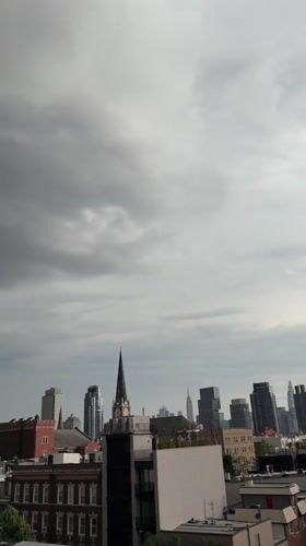 Rooftop observers document overcast evening skyline across NYC