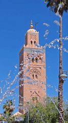 Pink mosque tower filmed through fountain in Marrakesh