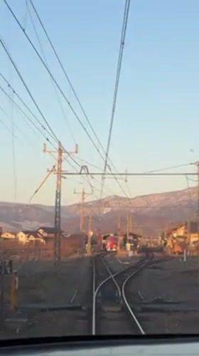 Train passenger films approach to Obuse station, red train visible