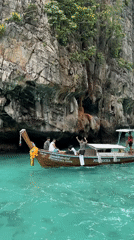 Boats navigate Ao Nang's turquoise bay beneath limestone cliffs