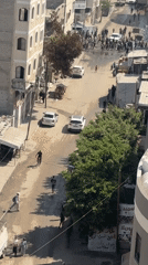 Crowds move through damaged Gaza streets amid building collapses