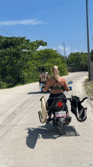 Woman rides surfboard-equipped scooter in General Luna, Philippines