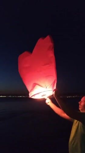 Evening sparklers and sky lanterns on Greek beach at sunset