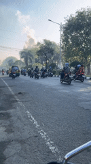 Busy road traffic through Candi with smoke visible in distance