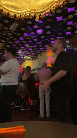 Vinyl record-lined bar in Riga, evening crowd at the counter